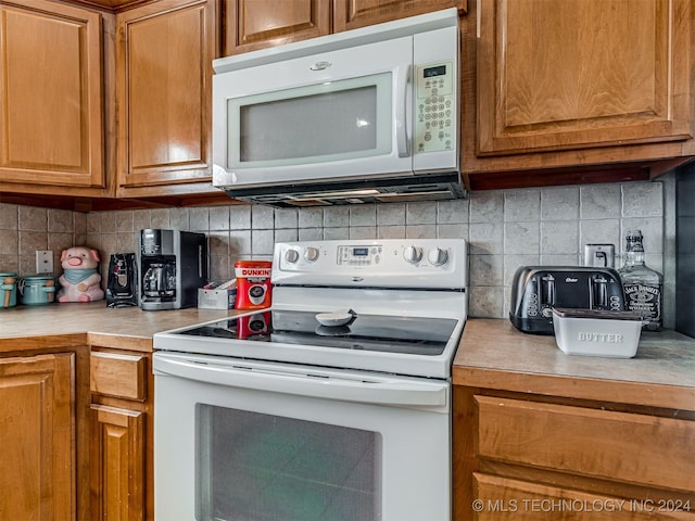 kitchen featuring white appliances and backsplash