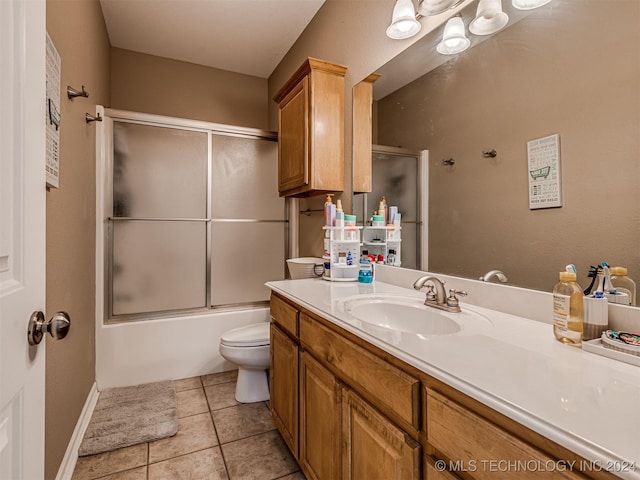 full bathroom featuring tile patterned floors, vanity, toilet, and bath / shower combo with glass door