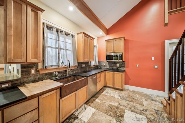 kitchen featuring sink, beam ceiling, stainless steel appliances, high vaulted ceiling, and decorative backsplash