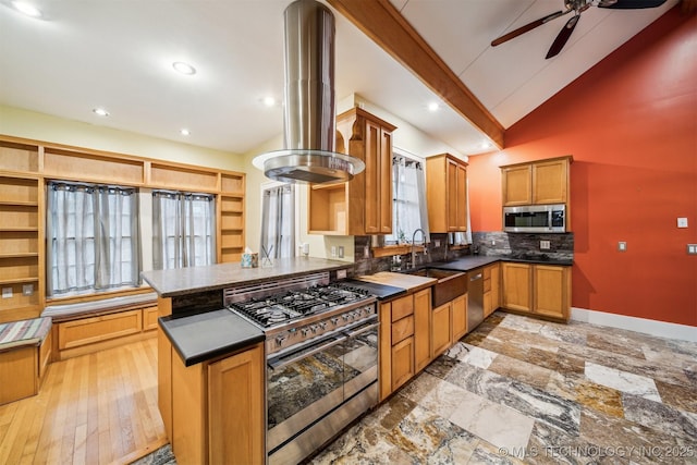 kitchen featuring appliances with stainless steel finishes, island range hood, lofted ceiling with beams, sink, and kitchen peninsula