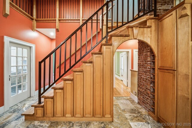 stairway featuring plenty of natural light and a high ceiling