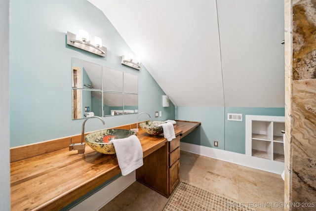 bathroom with vanity and vaulted ceiling