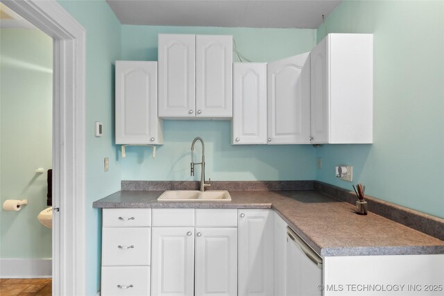 kitchen with dishwasher, sink, and white cabinets