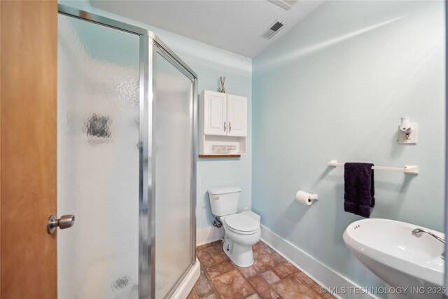 bathroom featuring an enclosed shower, sink, vaulted ceiling, and toilet