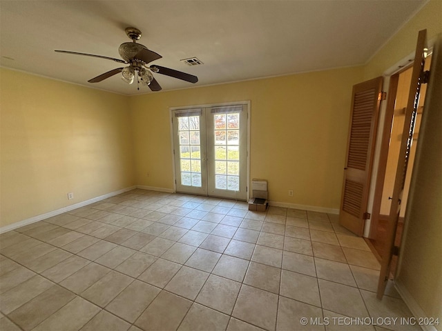 empty room with light tile patterned floors, ceiling fan, and ornamental molding