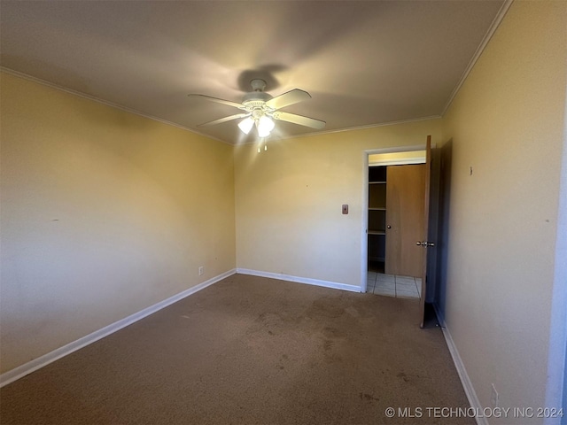 spare room featuring light carpet, crown molding, and ceiling fan