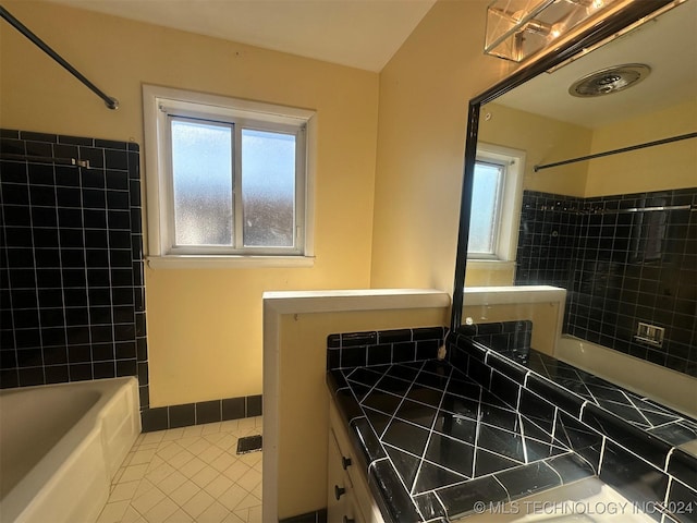 bathroom with tile patterned floors, a wealth of natural light, and bathtub / shower combination