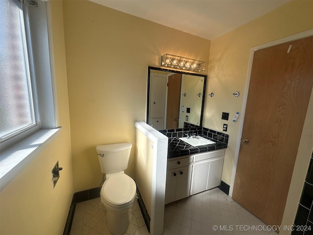 bathroom featuring tile patterned floors, vanity, and toilet