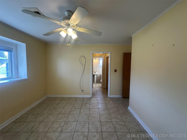 tiled empty room with ceiling fan, ornamental molding, and sink