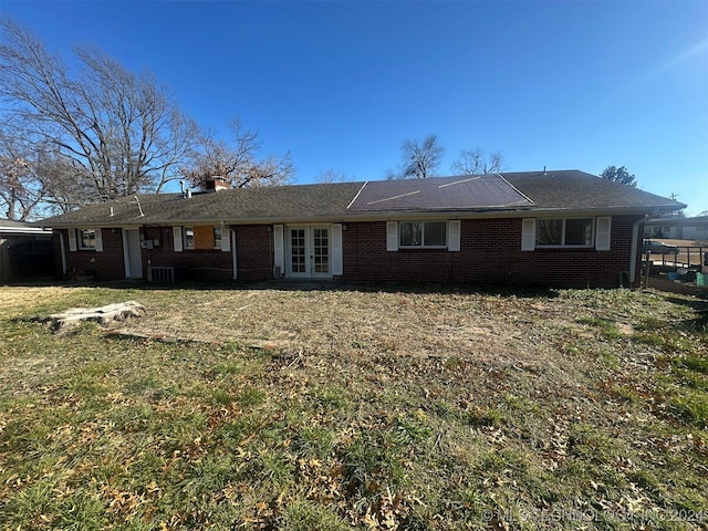 rear view of house with a yard, french doors, and cooling unit