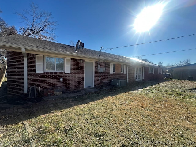 back of property featuring a lawn and central AC unit