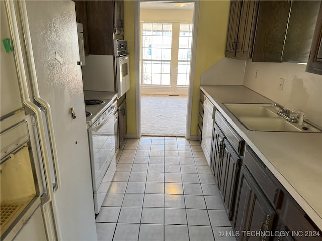 kitchen featuring dark brown cabinets, white range, sink, oven, and fridge