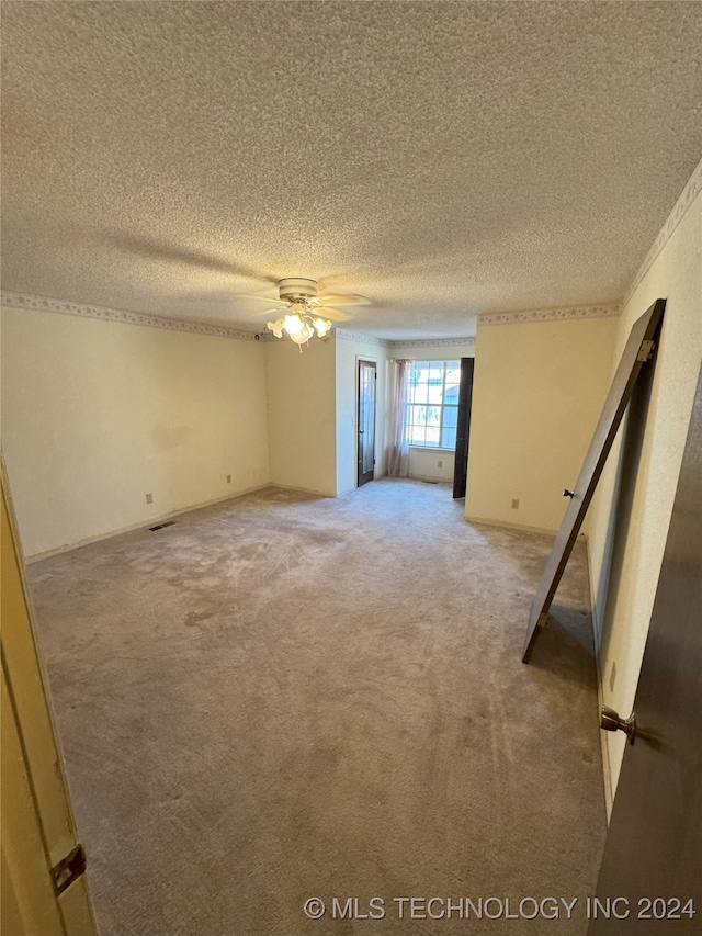 empty room featuring carpet, a textured ceiling, and ceiling fan