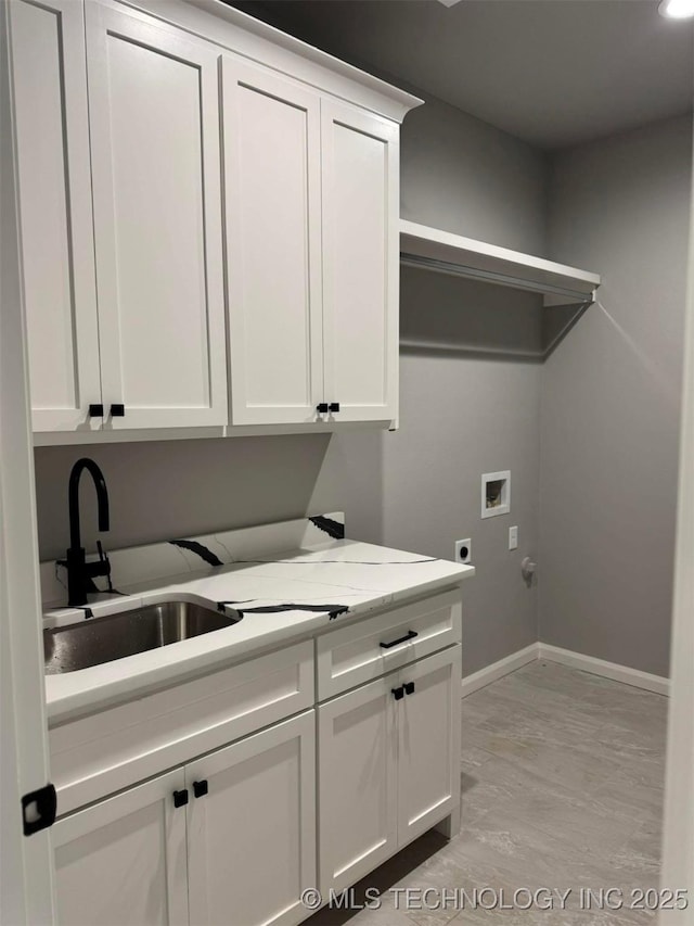 clothes washing area with sink, light hardwood / wood-style flooring, electric dryer hookup, hookup for a washing machine, and cabinets