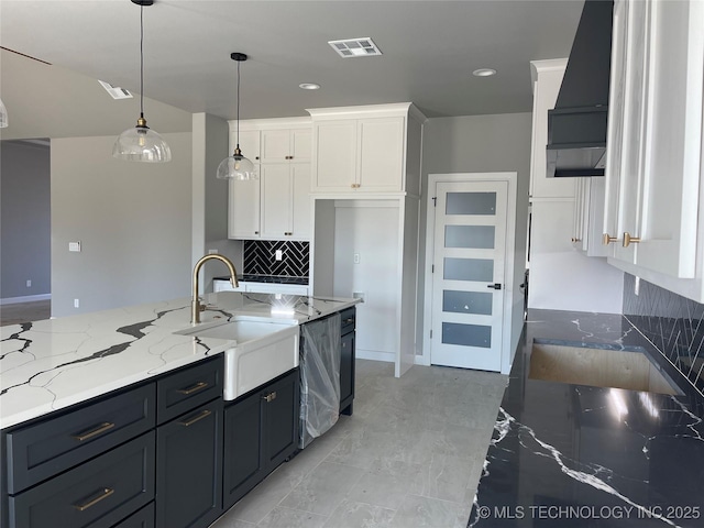 kitchen with dishwashing machine, sink, white cabinetry, hanging light fixtures, and light stone countertops