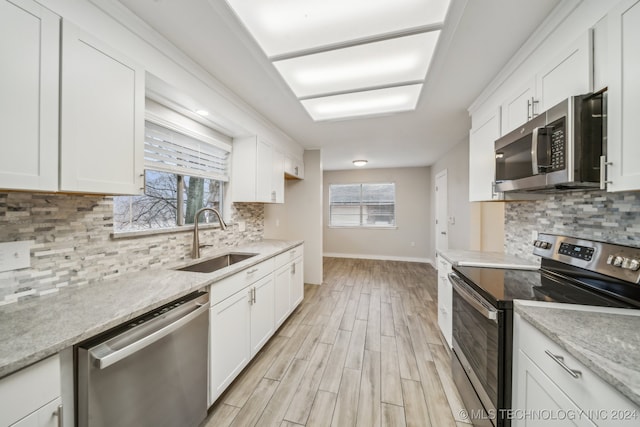 kitchen featuring white cabinetry, sink, light wood-type flooring, and appliances with stainless steel finishes