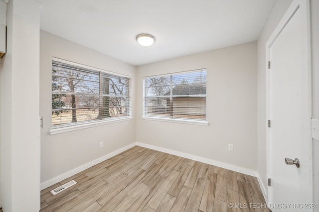 spare room featuring visible vents, baseboards, and light wood finished floors