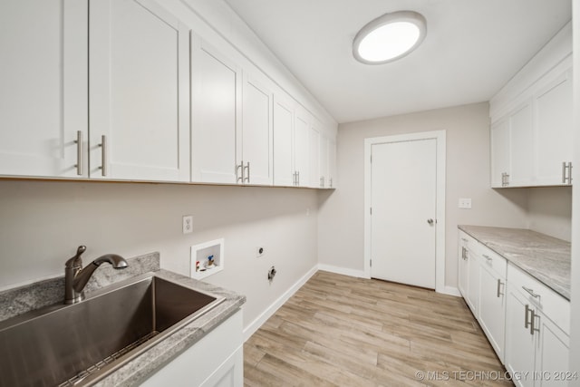 clothes washing area with electric dryer hookup, cabinets, sink, hookup for a washing machine, and light wood-type flooring