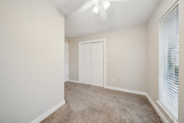 unfurnished bedroom featuring carpet flooring, ceiling fan, and a closet