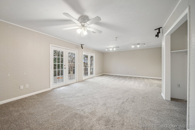 carpeted spare room with french doors, a ceiling fan, ornamental molding, and track lighting