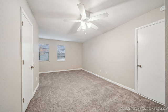 unfurnished room with ceiling fan and light carpet