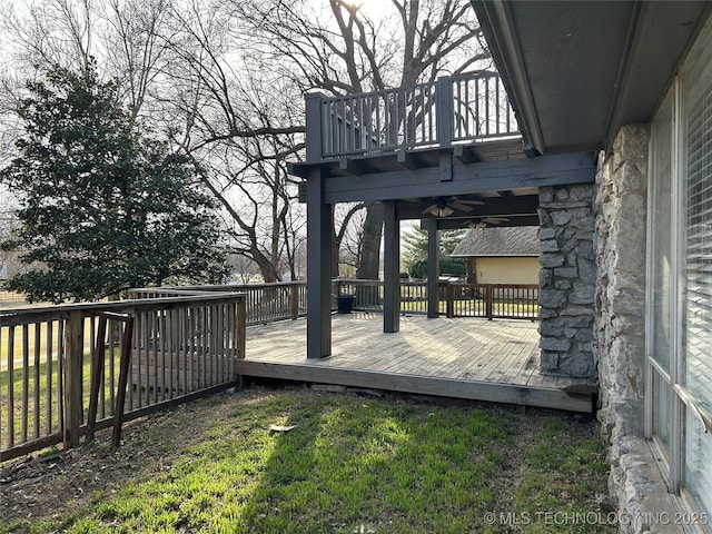 deck featuring ceiling fan and a yard