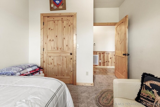 carpeted bedroom featuring wood walls