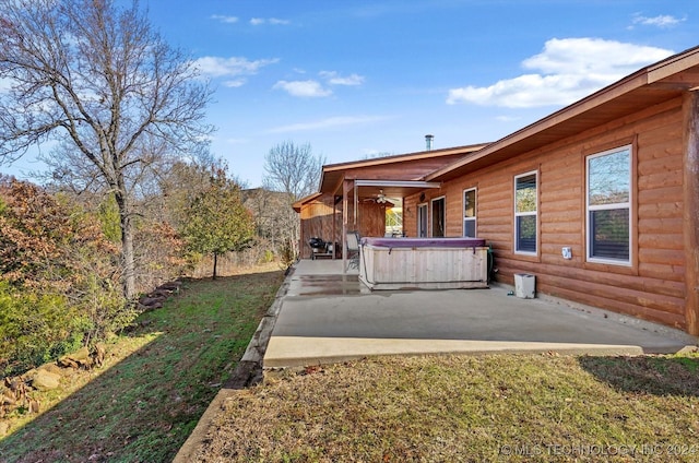 view of yard featuring a patio area, ceiling fan, and a hot tub