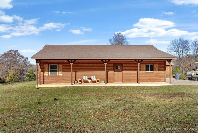 back of house with a patio area and a yard