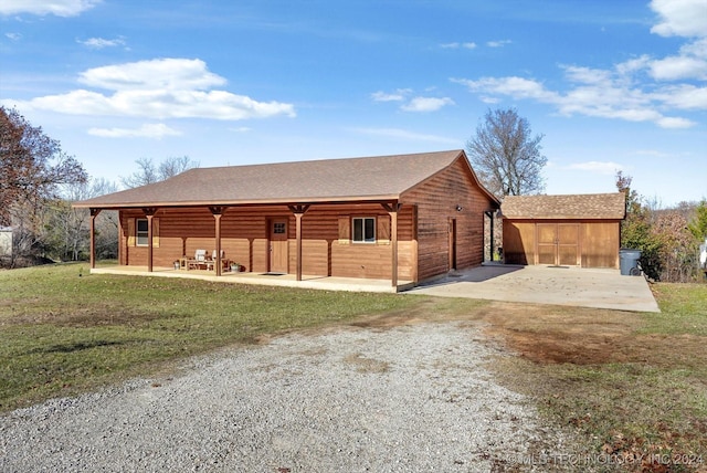 view of front facade with a front yard, a patio, and a shed