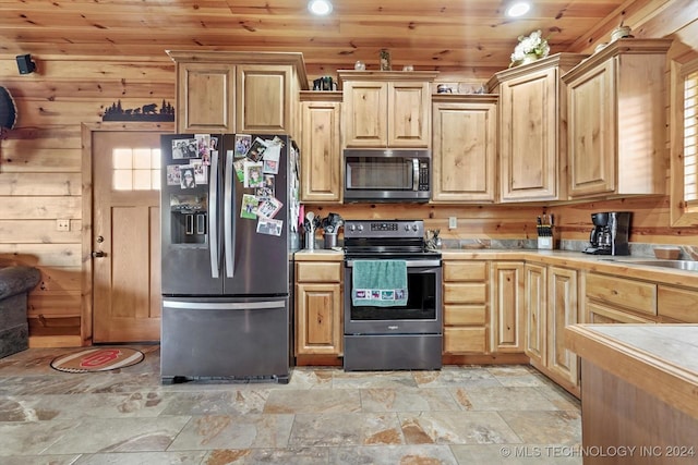 kitchen with wood walls, a healthy amount of sunlight, wood ceiling, and appliances with stainless steel finishes