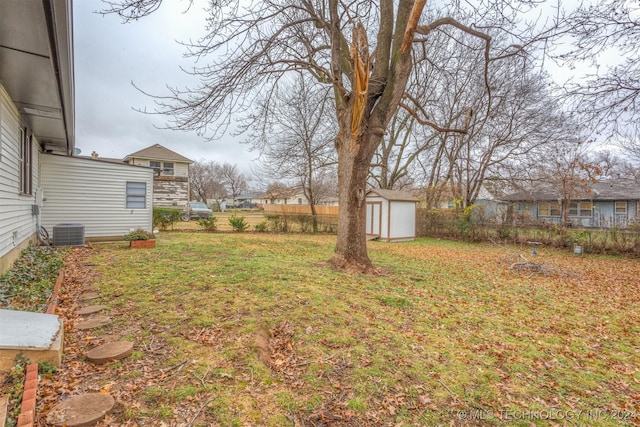 view of yard featuring central AC unit and a storage unit