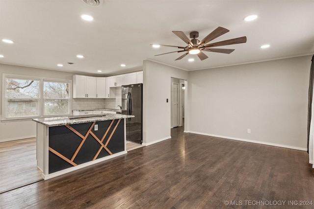 kitchen featuring black appliances, decorative backsplash, light stone countertops, dark hardwood / wood-style flooring, and white cabinetry