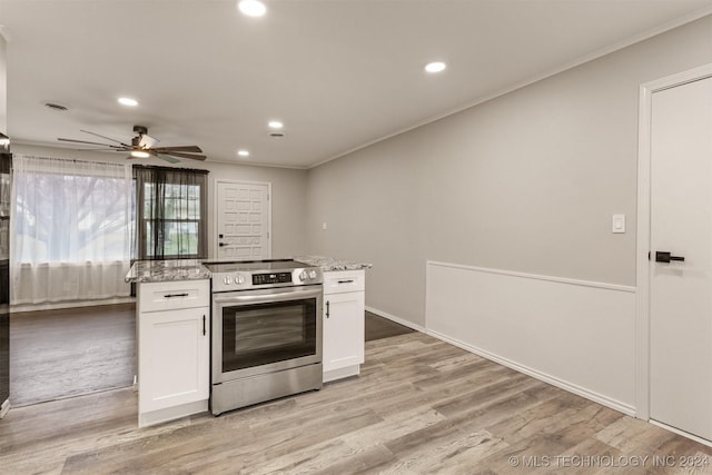 kitchen featuring stainless steel electric stove, light stone counters, white cabinetry, and light hardwood / wood-style flooring