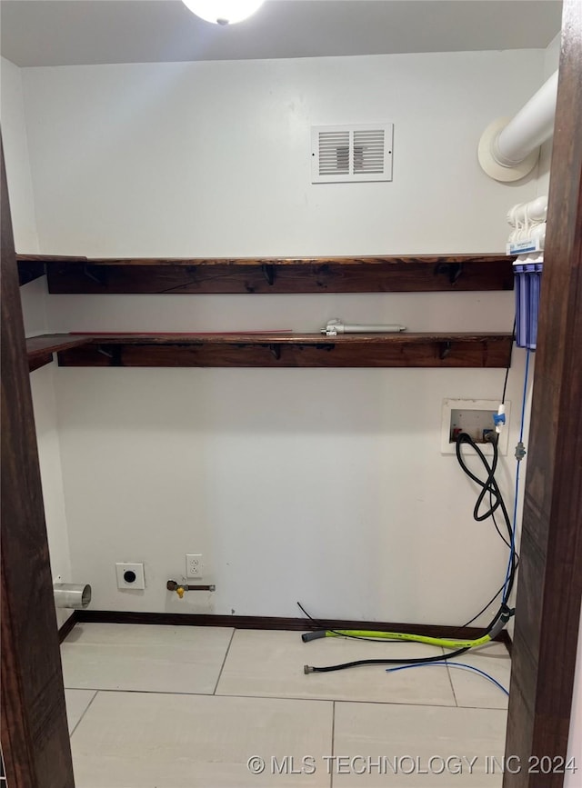 clothes washing area featuring electric dryer hookup, light tile patterned flooring, gas dryer hookup, and hookup for a washing machine