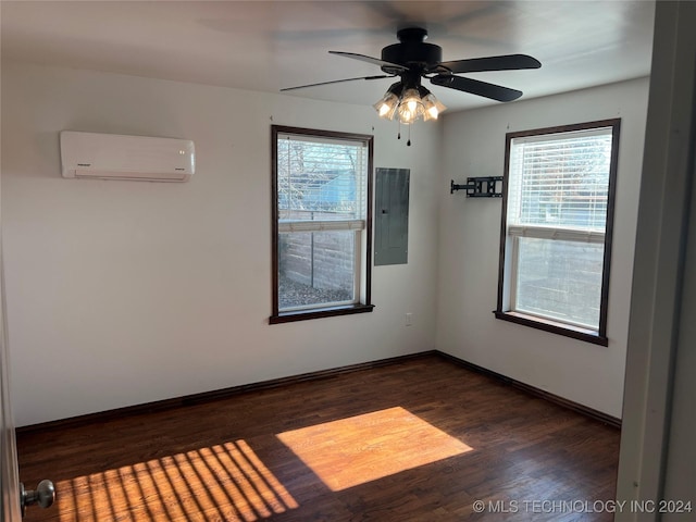 unfurnished room featuring a wall unit AC, electric panel, ceiling fan, and dark hardwood / wood-style floors