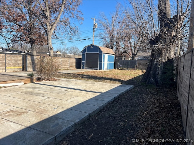 view of yard featuring a storage unit and a patio