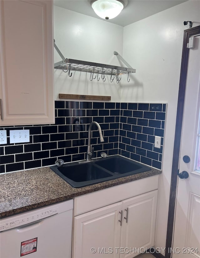 kitchen featuring white dishwasher, backsplash, white cabinetry, and sink