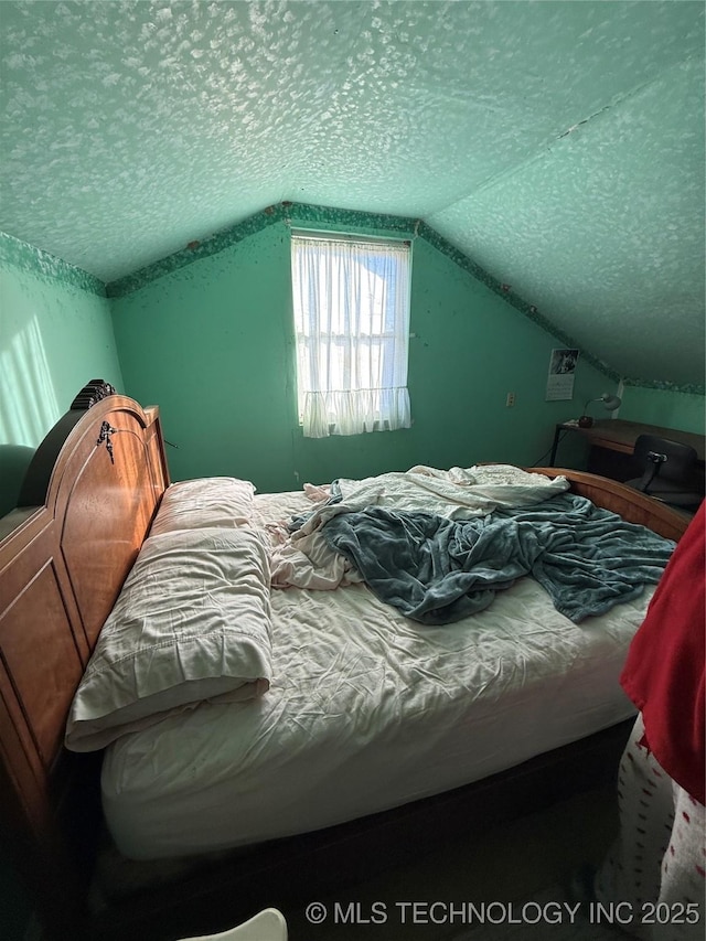 bedroom with lofted ceiling and a textured ceiling