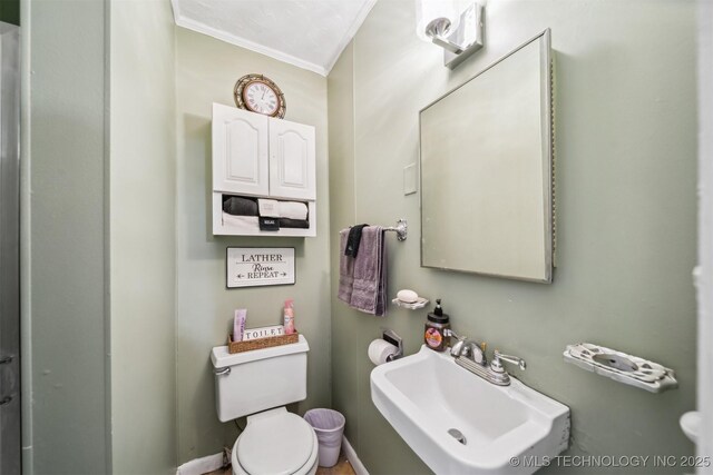 bathroom featuring sink, toilet, and ornamental molding