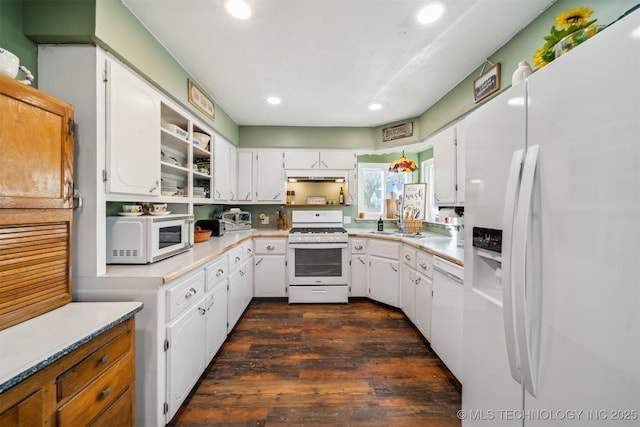 kitchen with sink, white appliances, white cabinets, and dark hardwood / wood-style floors