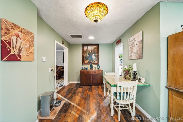 dining space featuring a textured ceiling and dark hardwood / wood-style flooring