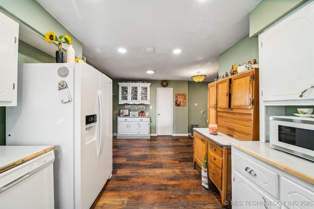 kitchen featuring white appliances, white cabinets, and dark hardwood / wood-style flooring