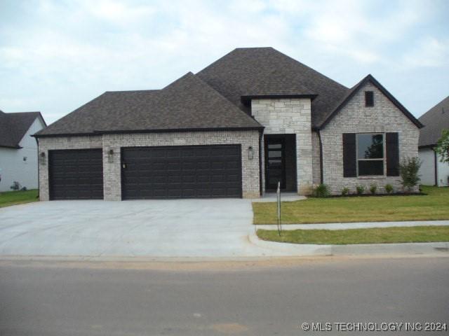 view of front of property featuring a front yard and a garage