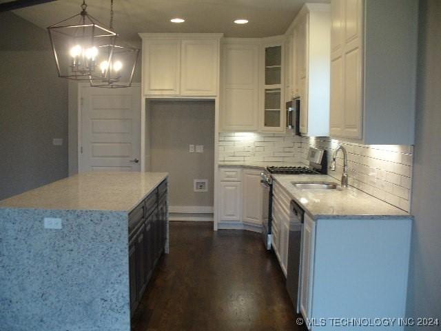 kitchen with dark hardwood / wood-style flooring, decorative light fixtures, white cabinetry, and stainless steel appliances