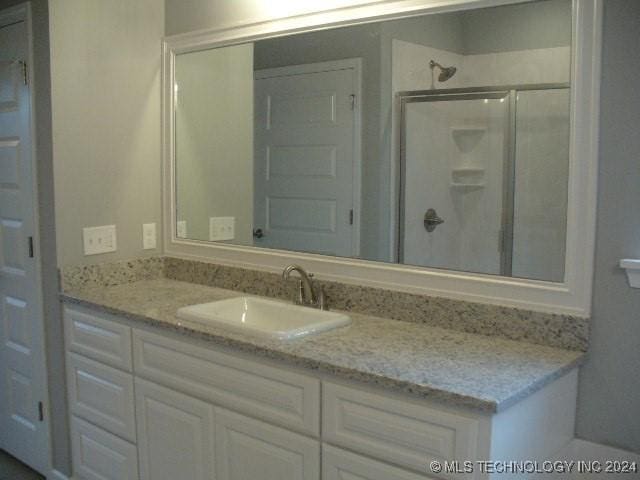 bathroom featuring vanity and an enclosed shower