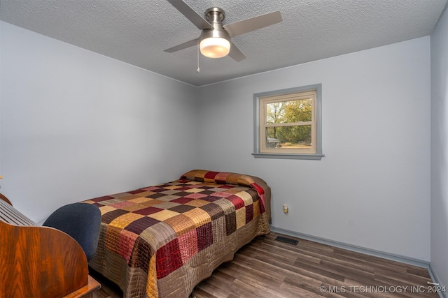 bedroom featuring a textured ceiling, dark hardwood / wood-style floors, and ceiling fan