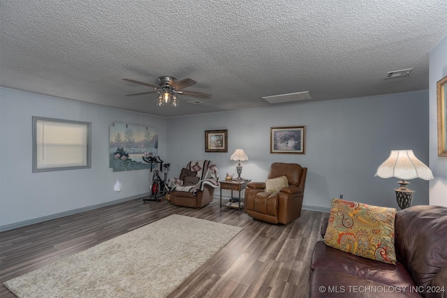 interior space featuring a textured ceiling, ceiling fan, and dark wood-type flooring