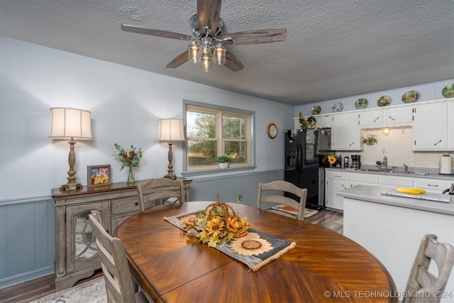 dining room with ceiling fan, light hardwood / wood-style flooring, a textured ceiling, and sink