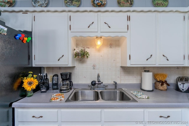 kitchen featuring white cabinets, backsplash, and sink